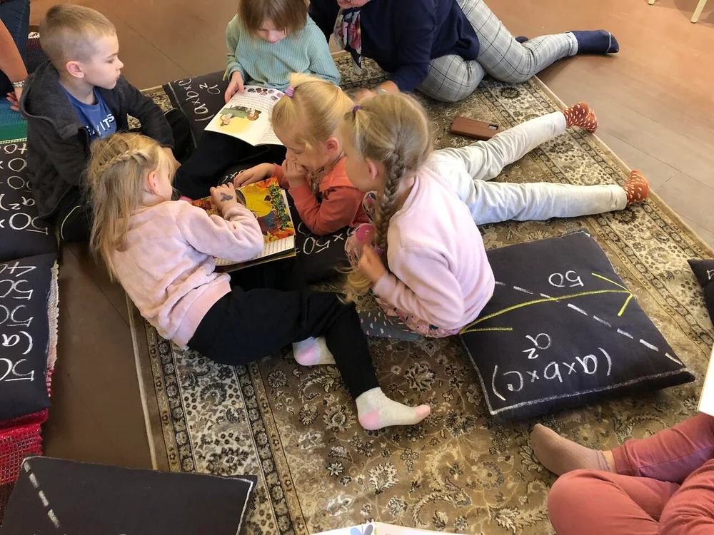 Lapsed uurivad koos raamatuid kirjastaja külaskäigul